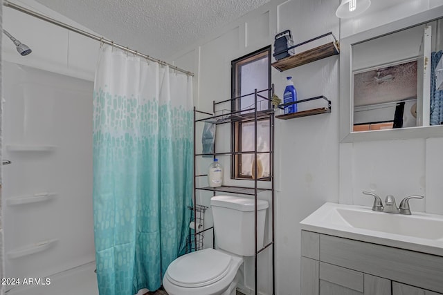 bathroom with oversized vanity, toilet, and a textured ceiling