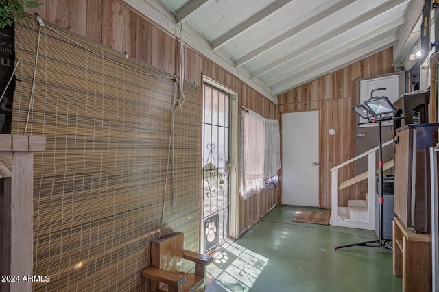 interior space featuring lofted ceiling with beams and wooden walls