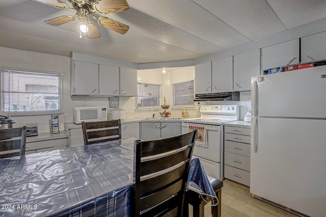 kitchen featuring white cabinetry, ceiling fan, white appliances, and light tile floors