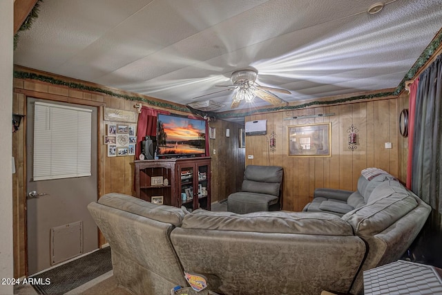 carpeted living room with wooden walls, a wall mounted air conditioner, and ceiling fan