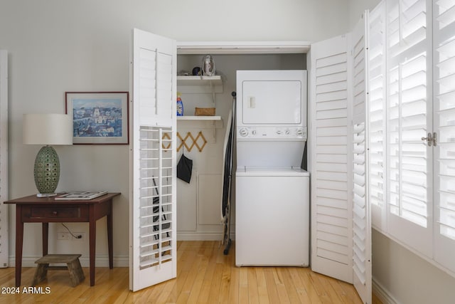 2201 N Central Ave Unit 4E, Phoenix, AZ 85004 - laundry room featuring stacked washer / drying machine, light wood-style floors, and baseboards