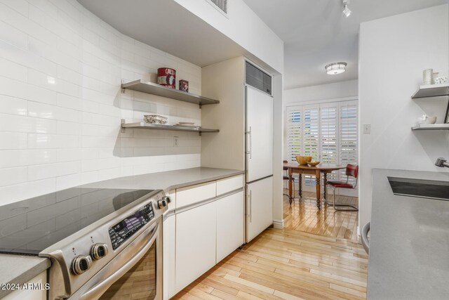 2201 N Central Ave Unit 4E, Phoenix, AZ 85004 - kitchen with stainless steel electric range oven, open shelves, light wood-type flooring, a sink, and white built in fridge