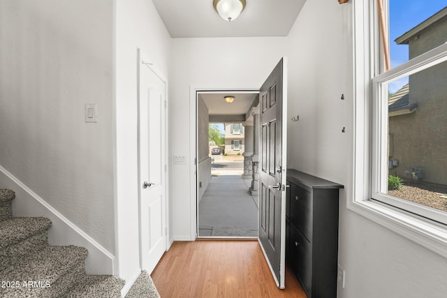 2337 E Fraktur Rd, Phoenix, AZ 85040 - doorway to outside featuring stairway, baseboards, and light wood finished floors