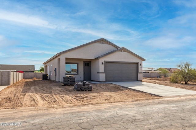 view of front of property featuring central AC and a garage