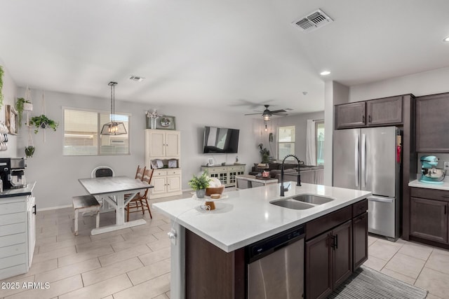 kitchen with dark brown cabinetry, visible vents, appliances with stainless steel finishes, light countertops, and a sink