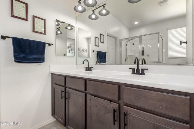 full bath with baseboards, double vanity, a sink, and a shower stall