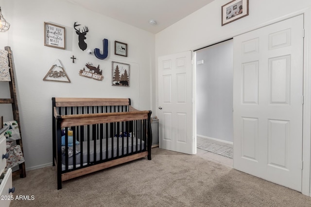 carpeted bedroom with a crib and baseboards