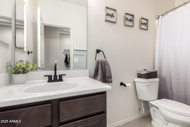 bathroom with tile patterned flooring, vanity, toilet, and baseboards