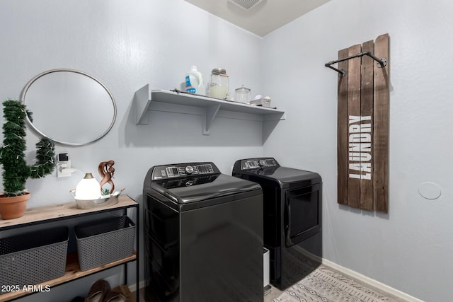 washroom with laundry area, baseboards, and washer and clothes dryer