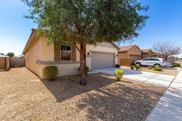 view of front of home with an attached garage, a tiled roof, concrete driveway, and stucco siding