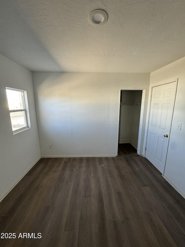 spare room with dark wood-type flooring and a textured ceiling