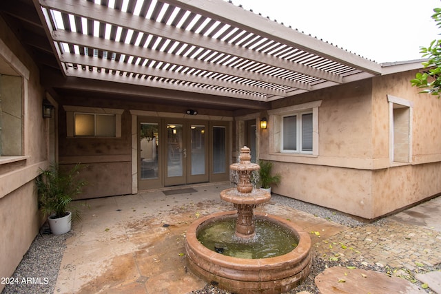 entrance to property featuring a pergola, french doors, and a patio area