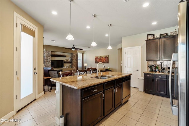 kitchen featuring stainless steel appliances, dark brown cabinetry, a sink, and an island with sink