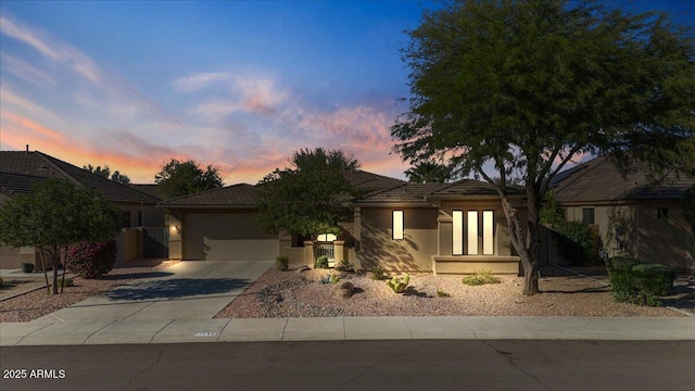 view of front of property with an attached garage, a tile roof, concrete driveway, and stucco siding