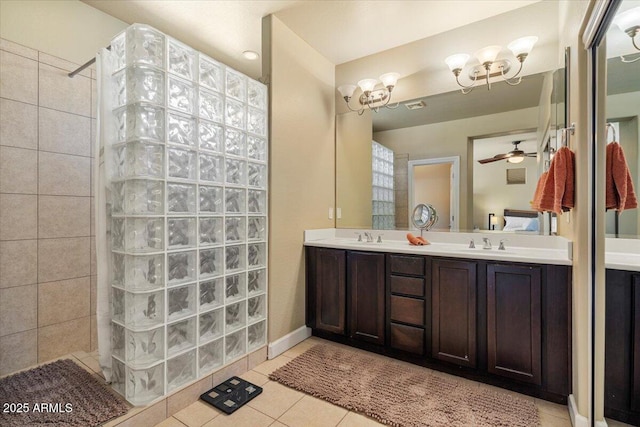 bathroom featuring double vanity, ceiling fan, tile patterned floors, a walk in shower, and a sink