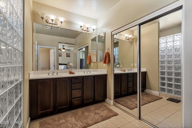 bathroom featuring double vanity, ensuite bath, a sink, and tile patterned floors