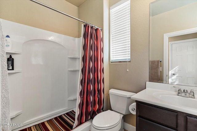 bathroom with a shower with shower curtain, vanity, and toilet