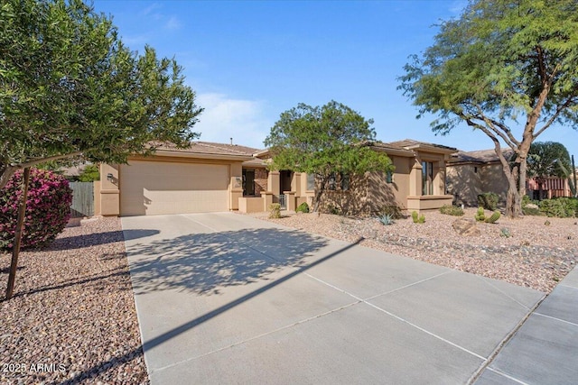 view of front facade with driveway, fence, an attached garage, and stucco siding