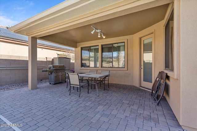 view of patio / terrace with a grill, fence, and outdoor dining space
