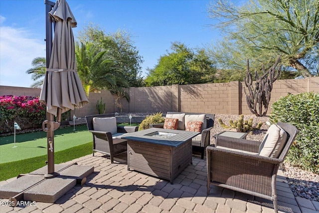 view of patio / terrace with an outdoor living space with a fire pit and a fenced backyard