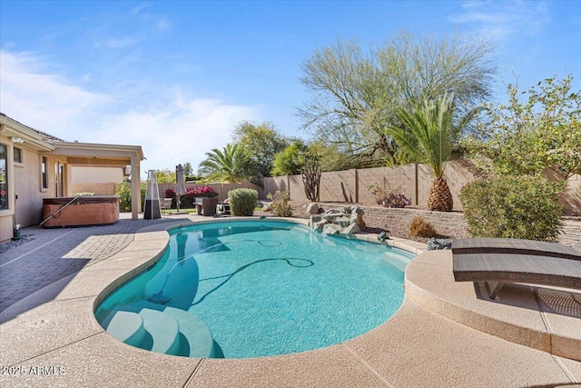 view of swimming pool featuring a patio area, a hot tub, a fenced in pool, and a fenced backyard