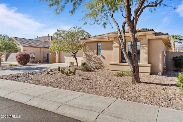 view of front of property with a garage, concrete driveway, and stucco siding