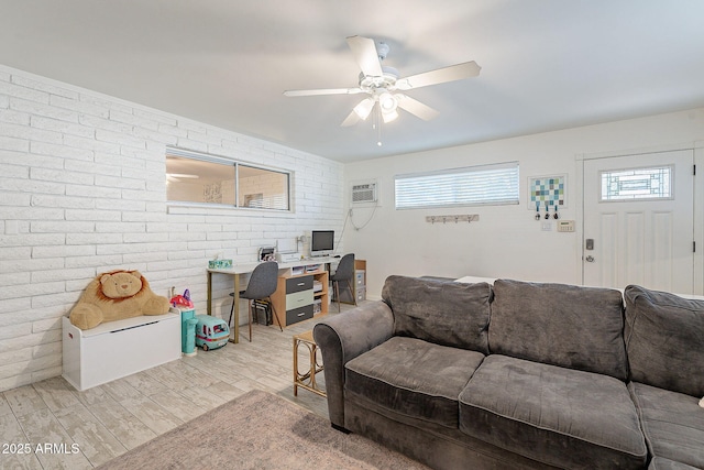 living room featuring brick wall, a wall mounted AC, wood finished floors, and a ceiling fan