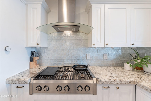 kitchen with stainless steel gas cooktop, white cabinets, backsplash, light stone countertops, and wall chimney exhaust hood