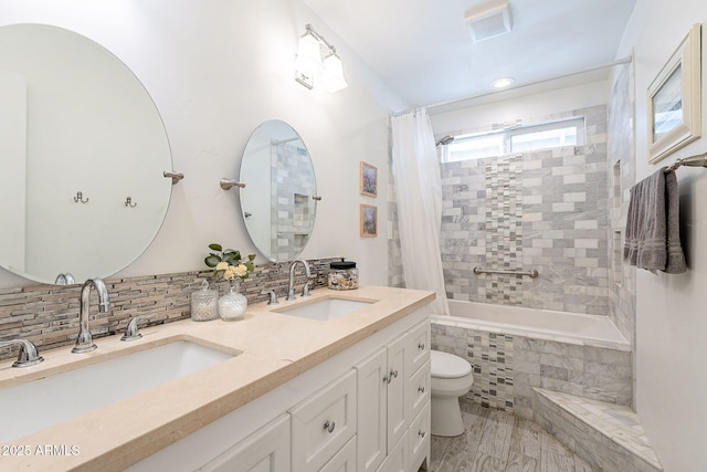 full bath with toilet, a sink, tiled shower / bath combo, and decorative backsplash