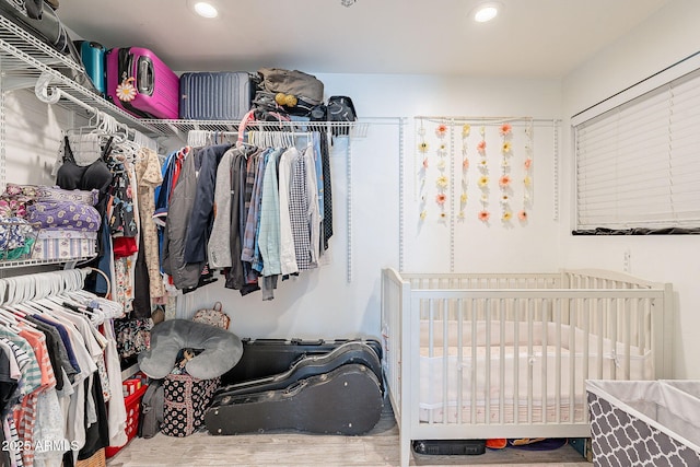 walk in closet with wood finished floors