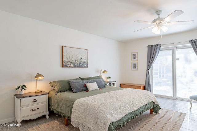 bedroom with ceiling fan, wood finished floors, and access to exterior