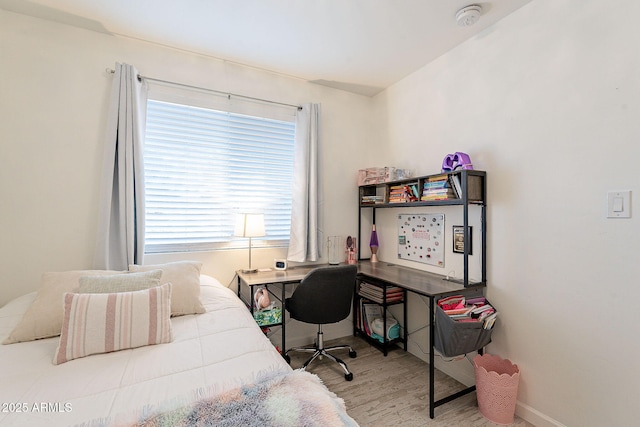 bedroom featuring baseboards and wood finished floors