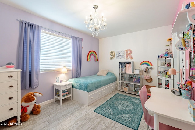 bedroom with light wood-style floors, a notable chandelier, and baseboards