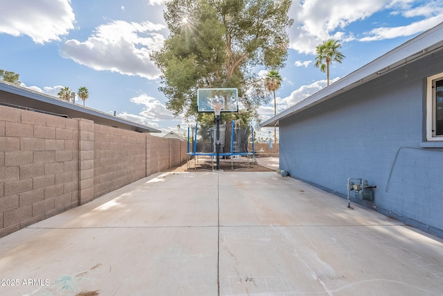 view of patio featuring a trampoline and fence