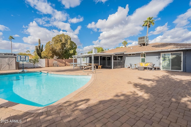 view of pool with cooling unit, fence, a sunroom, a fenced in pool, and a patio area