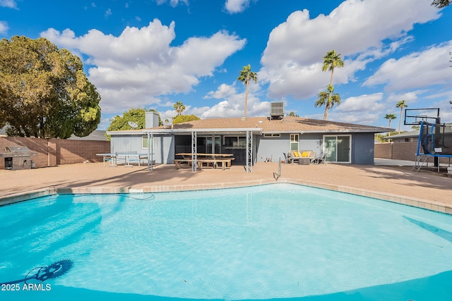 view of pool with a patio area, a trampoline, fence, and a fenced in pool