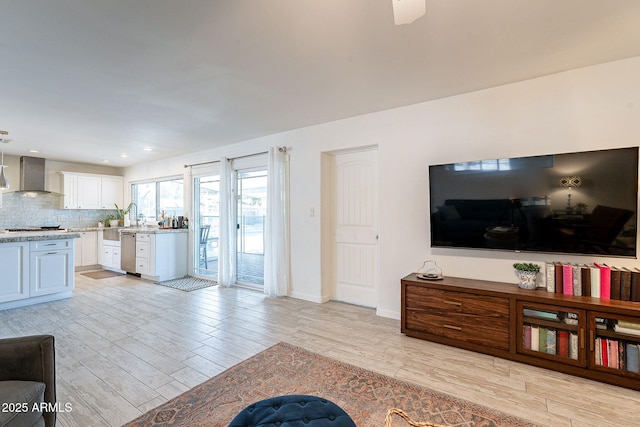 living area with light wood-type flooring, baseboards, and recessed lighting