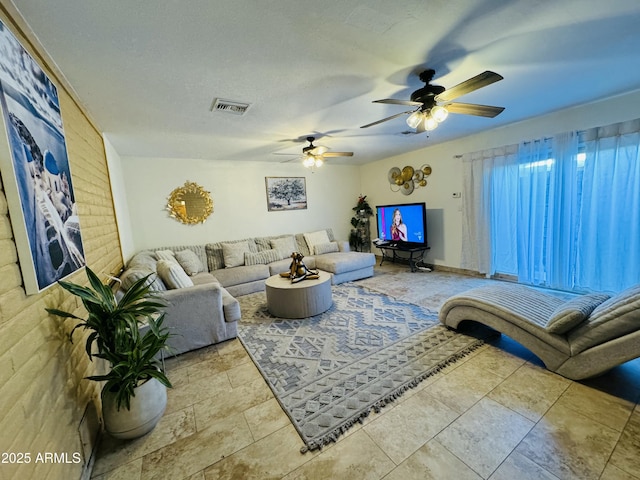 living room featuring ceiling fan and a textured ceiling