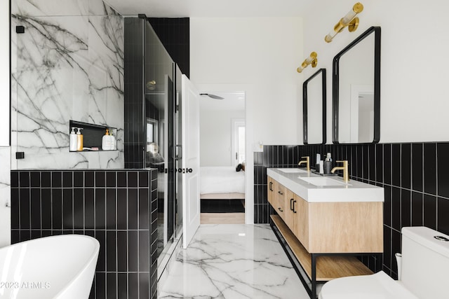 full bathroom featuring vanity, separate shower and tub, tile walls, and toilet