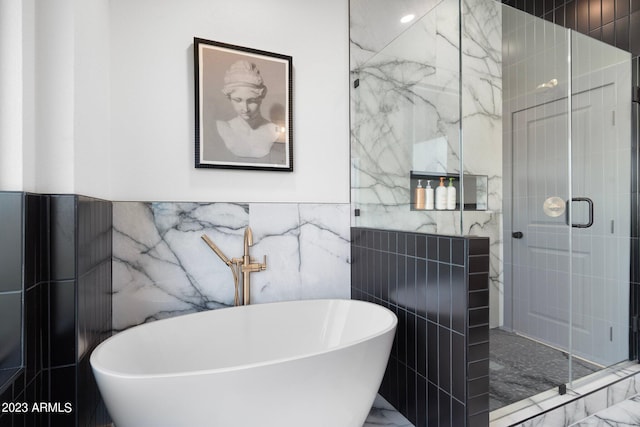 bathroom with tile walls and independent shower and bath