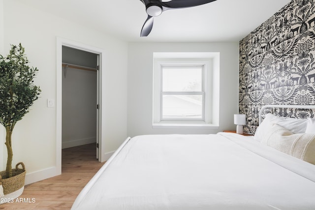 bedroom featuring ceiling fan, a spacious closet, hardwood / wood-style floors, and a closet