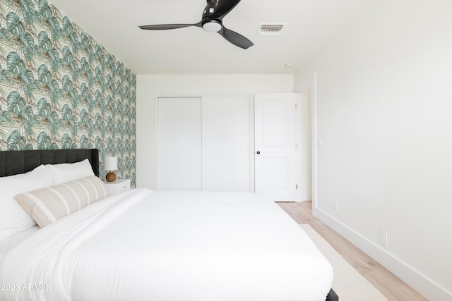 bedroom with ceiling fan, light wood-type flooring, and a closet