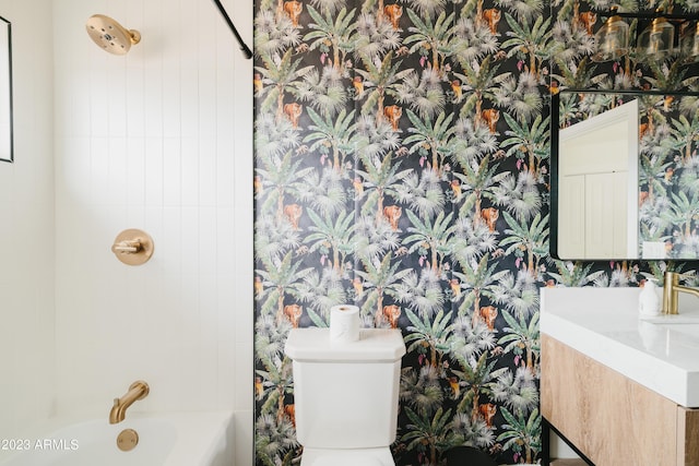 full bathroom featuring vanity, tiled shower / bath, and toilet