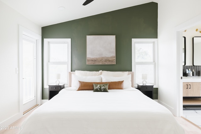 bedroom with lofted ceiling and connected bathroom