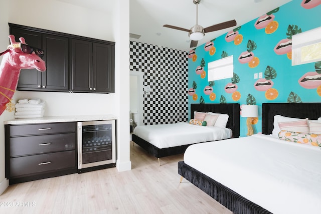 bedroom with wine cooler and light hardwood / wood-style floors