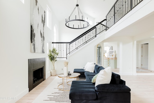 living room featuring a chandelier, light hardwood / wood-style floors, and a high ceiling