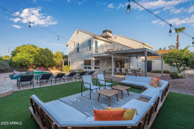 back of house featuring an outdoor living space, a lawn, a patio, and a balcony