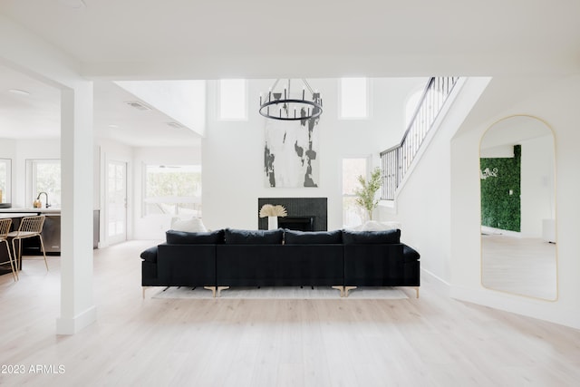 living room featuring sink, an inviting chandelier, and light hardwood / wood-style floors