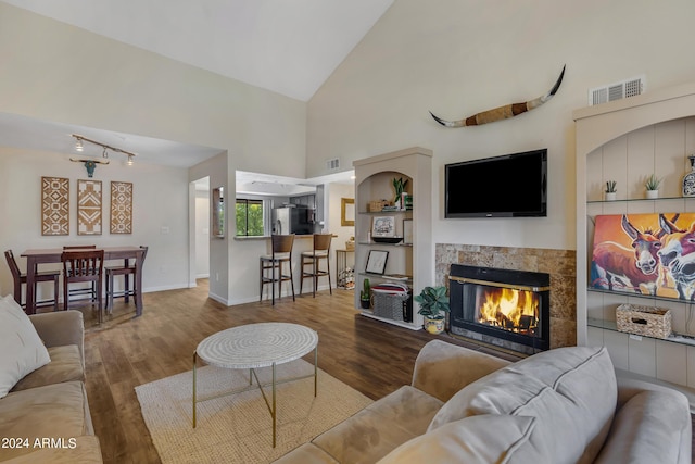 living room with visible vents, wood finished floors, and a tiled fireplace