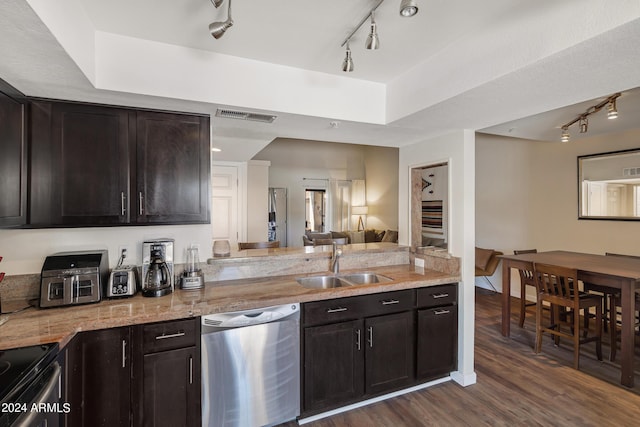 kitchen with visible vents, a sink, dishwasher, a tray ceiling, and dark wood-style flooring